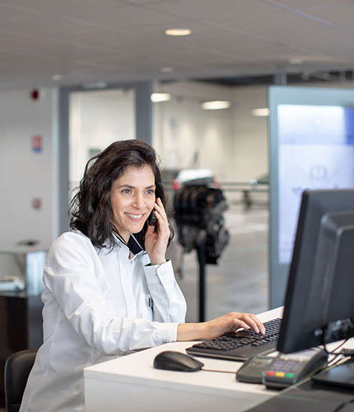 Жінка говорить по телефону перед монітором комп’ютера