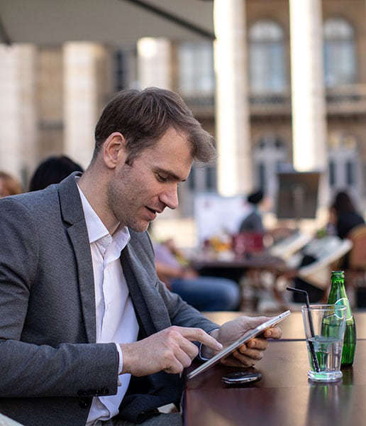 Чоловік дивиться на екран планшета у столовій