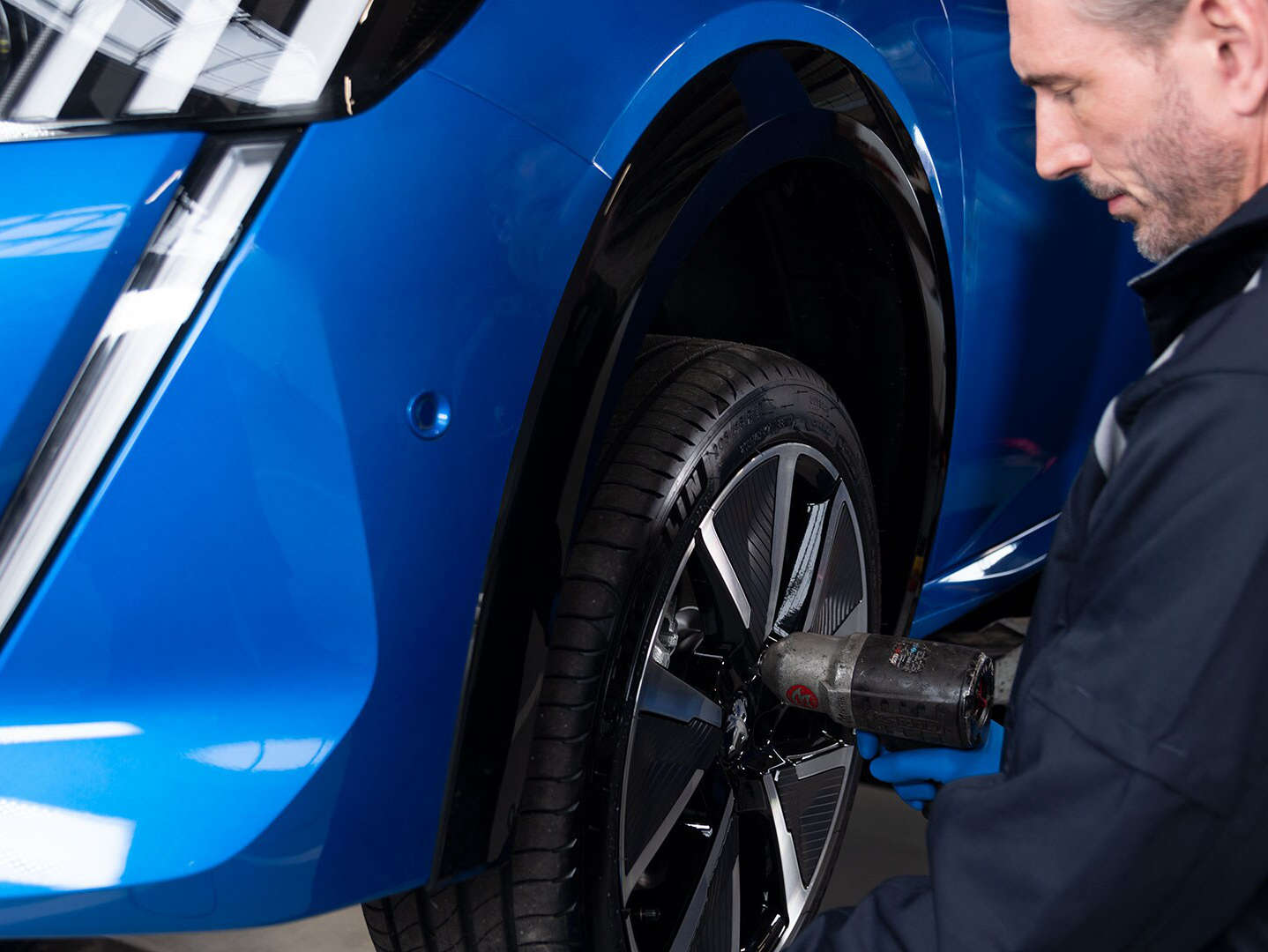 Майстер демонтує колесо з автомобіля Peugeot