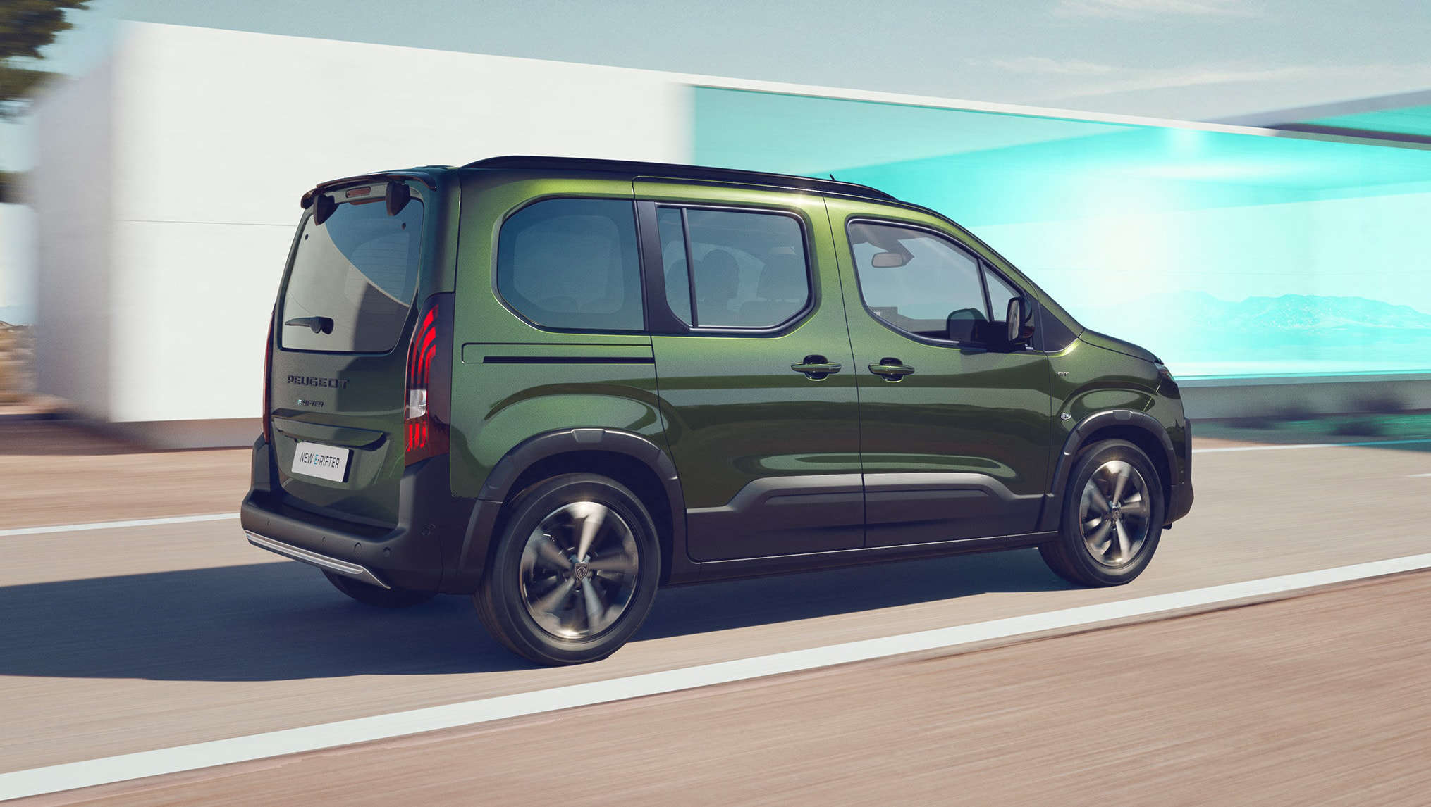 Peugeot e-Rifter зеленого кольору у русі, вигляд ззаду з правого боку