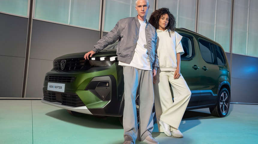 Чоловік й жінка стоять разом перед Peugeot Rifter