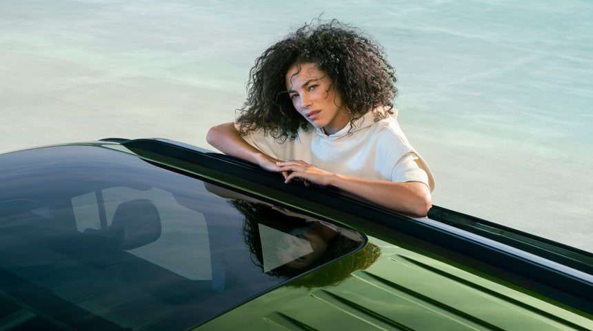 Жінка сперлася ліктями на дах Peugeot Rifter