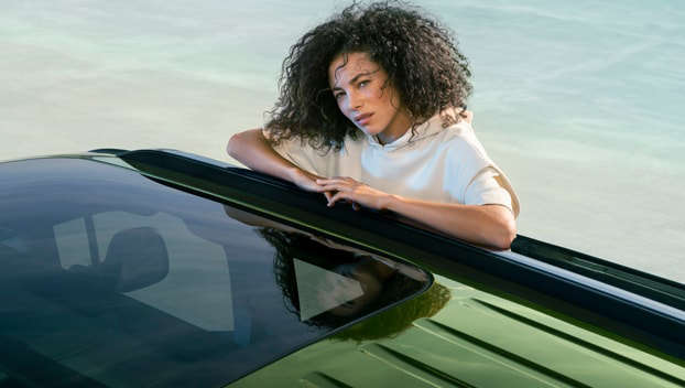 Жінка сперлася ліктями на дах Peugeot Rifter